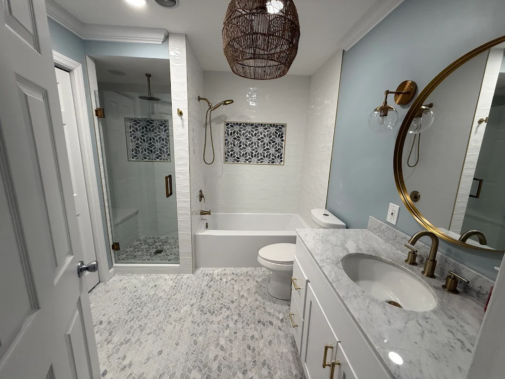 White vanity, pale patterned countertop and round mirror in the completed New City bathroom