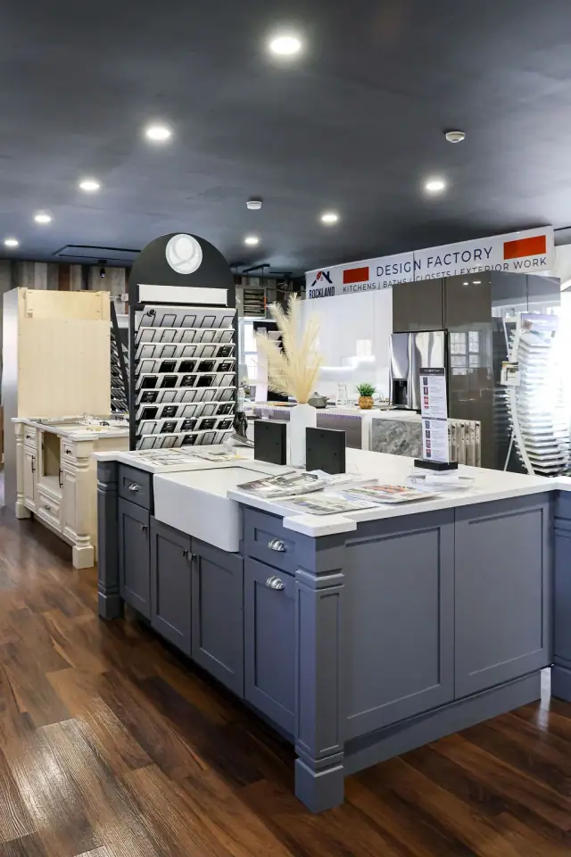Blue-gray island display beneath showroom spotlights