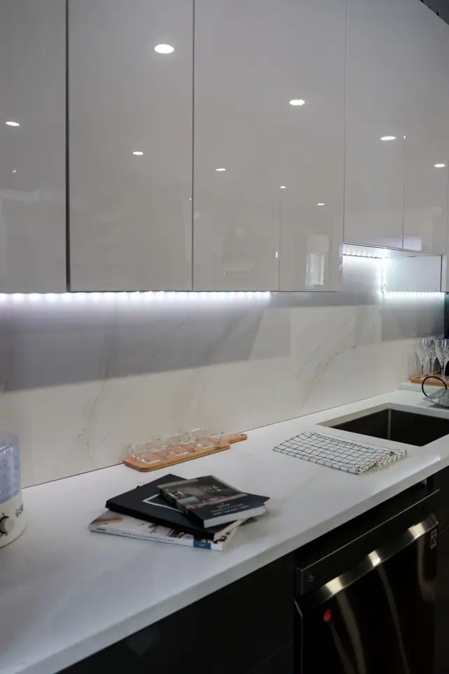 Gray cabinet counter with sink and illuminated backsplash