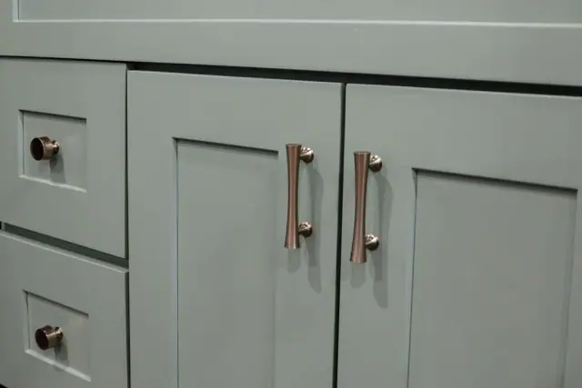 Sage cabinet drawers with mixed brass hardware