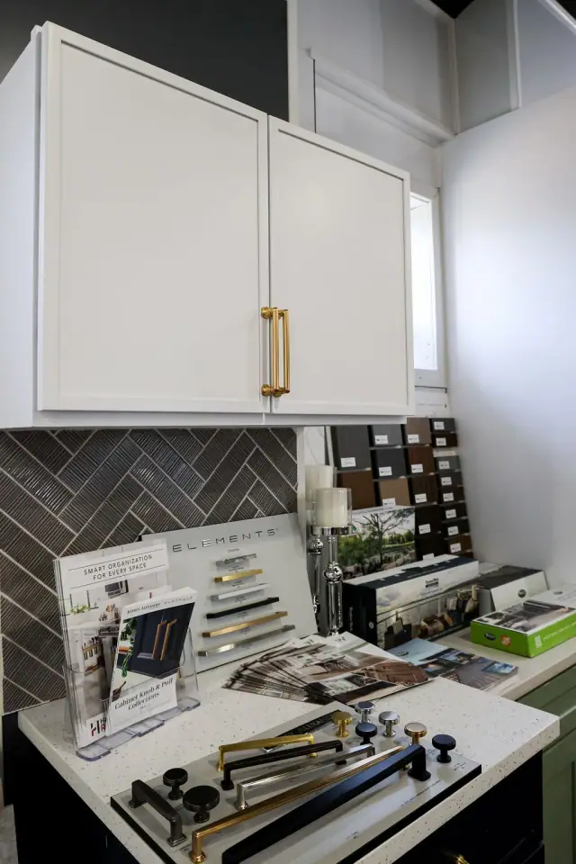 White upper cabinets above a patterned backsplash sample
