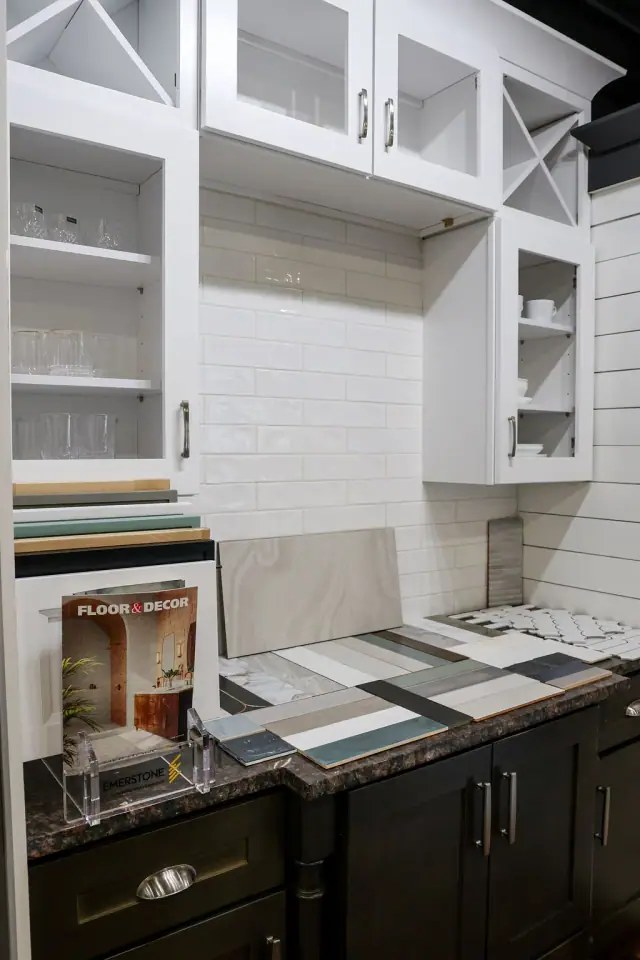 White glass-front cabinetry above a black countertop