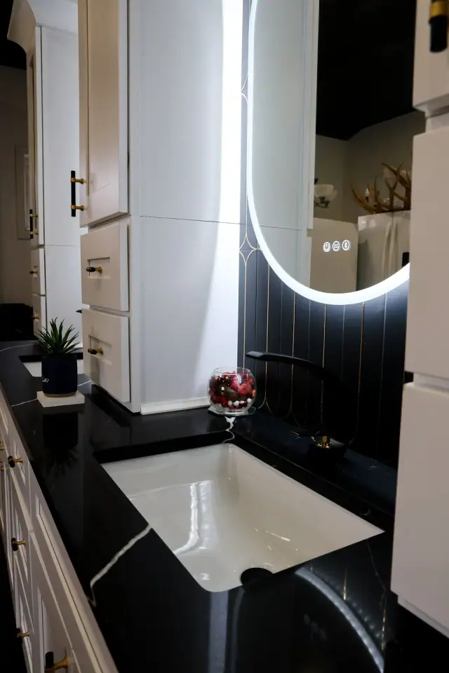 Dark vanity and oval mirror display viewed from the doorway