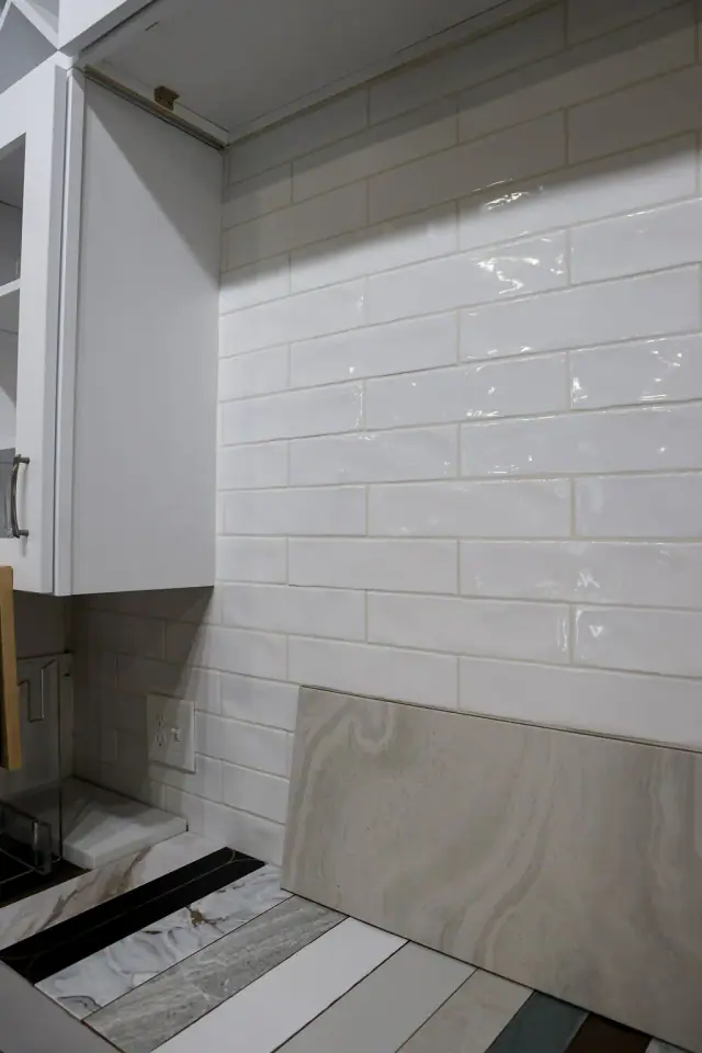 White sink alcove with small square backsplash tile