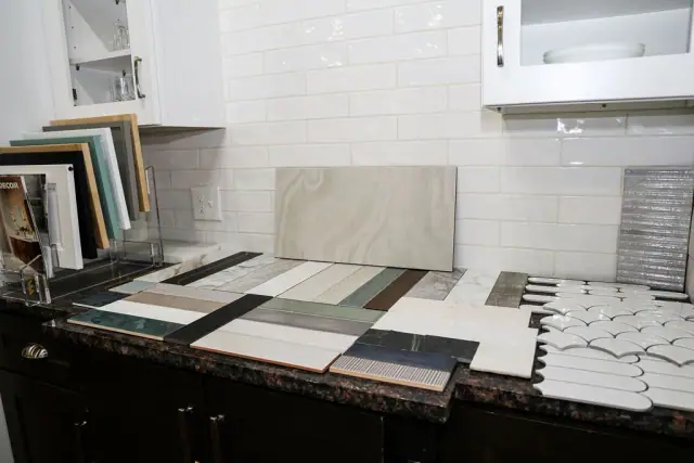 Countertop and backsplash sample slabs layered on a cabinet