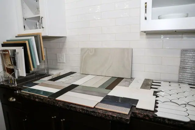 Countertop slabs and framed samples on a dark cabinet
