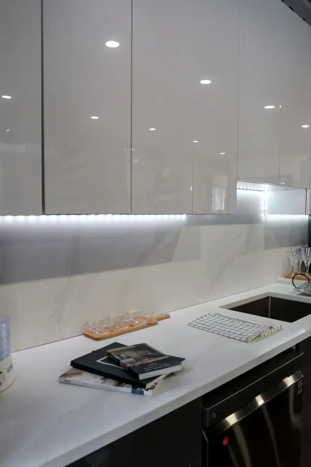 Gray sink display with illuminated stone-look backsplash
