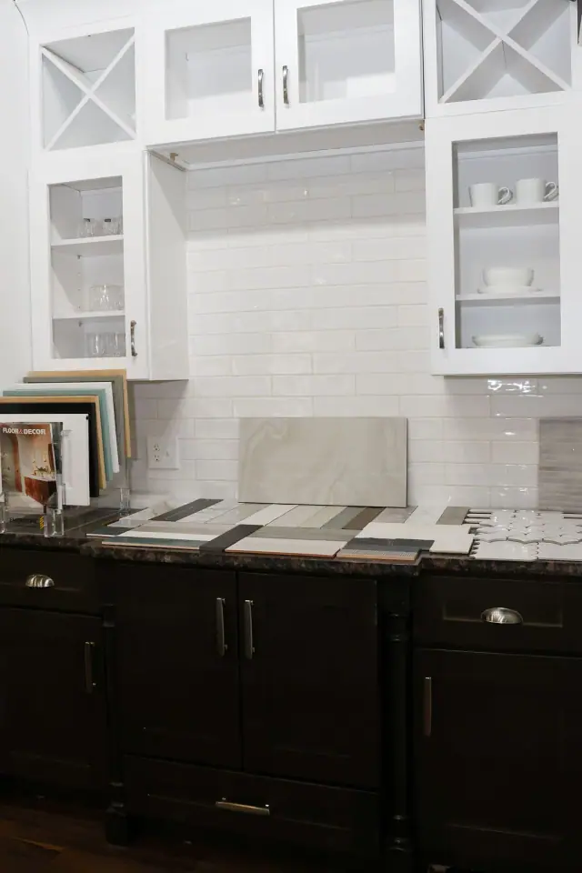 White glass-front wall cabinets above dark countertops