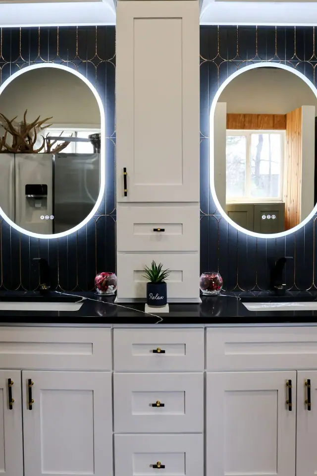 Pair of illuminated oval mirrors above a long vanity