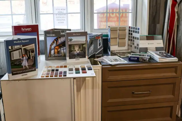 Wood cabinet sample station with brochures near tall windows