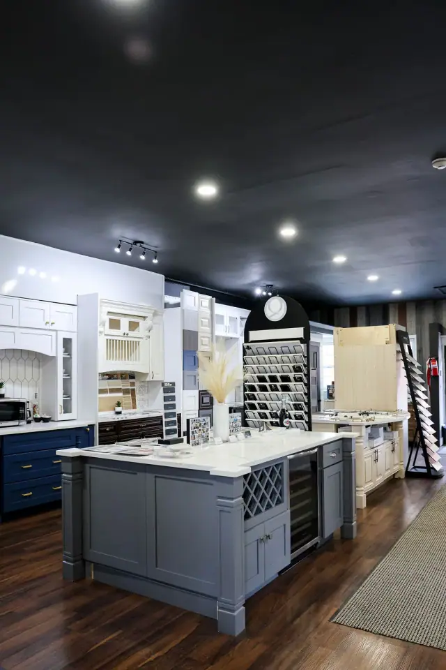 Blue-gray island and white cabinet displays under spotlights