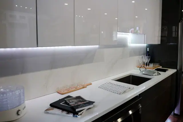 Gray cabinet sink run with illuminated backsplash