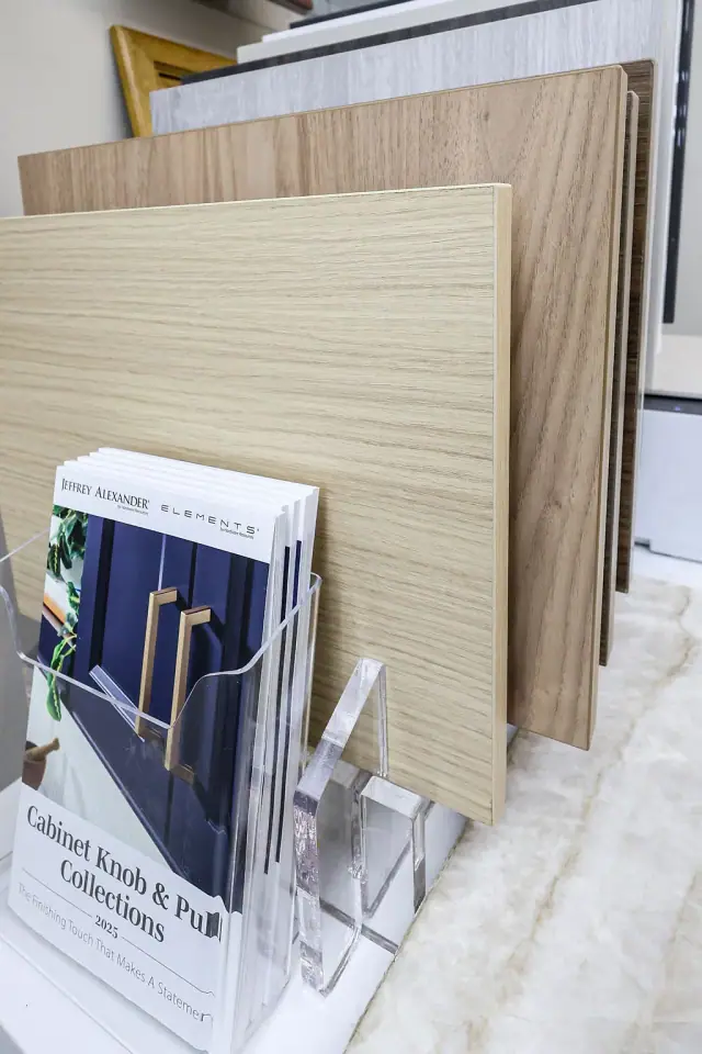 Wood cabinet door and finish samples on a showroom desk