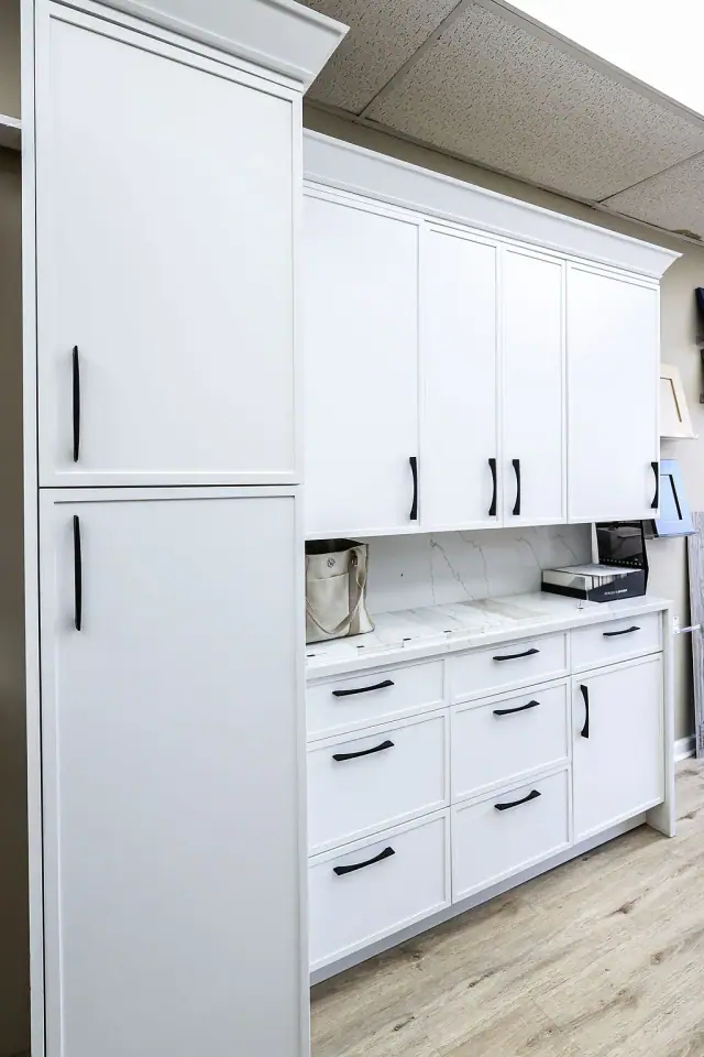 White cabinet wall with drawers and black hardware