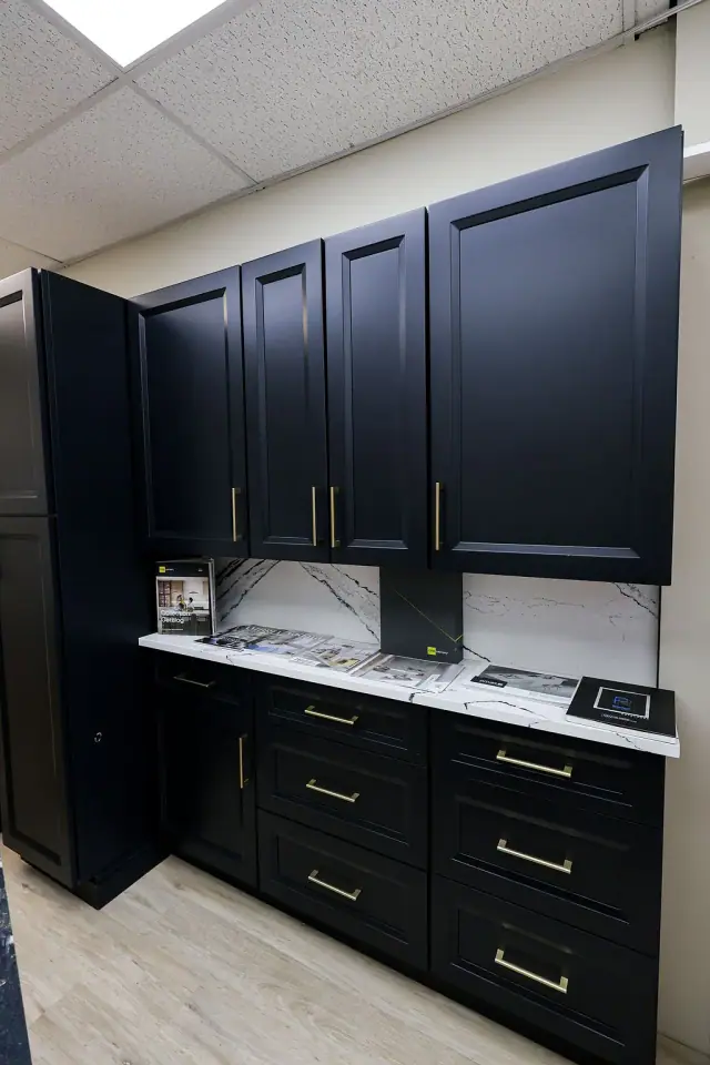 Dark cabinet display with glass-front uppers and brass pulls