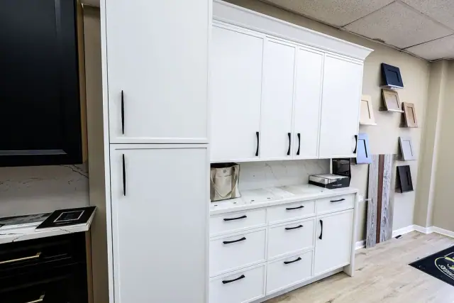White cabinet run with black countertop and mixed hardware