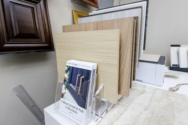 Dark wood door samples and pale slab boards on a desk