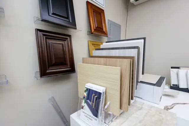 Framed cabinet doors and wood finish samples on a desk